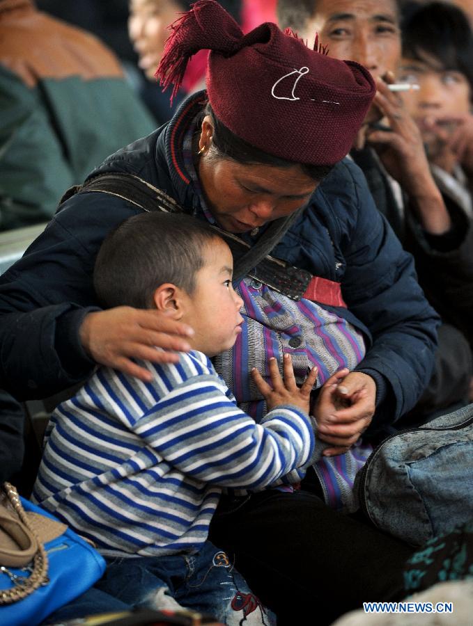 A boy waits with his relative at the railway station in Chengdu, capital of southwest China's Sichuan Province, Feb. 22, 2013. As the number of travellers rises before the Lantern Festival, many children went back with their parents back to the workplaces. (Xinhua/Xue Yubin) 