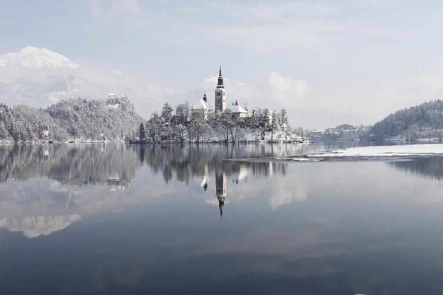 A church and a castle are seen at Lake Bled in northwestern Slovenia, Feb. 23, 2013. A heavy snowfall on Friday night shrouded the beautiful glacial lake, a popular tourist destination about 55km from the capital city Ljubljana. (Xinhua/Zhao Yi)