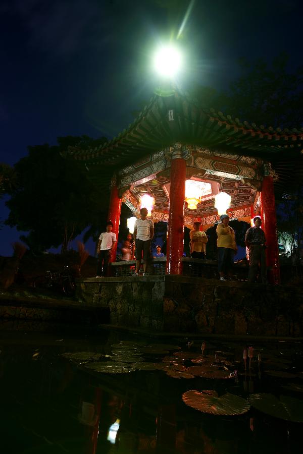 People rest under Chinese lanterns at a Chinese style pavilion during the 12th China-Philippines Traditional Cultural Festival and Suzhou Cultural Exhibition at the Rizal Park in Manila, the Philippines, Feb. 23, 2013. The 12th China-Philippines Traditional Cultural Festival and Suzhou Cultural Exhibition opened here on Saturday, one day ahead of the Chinese Lantern Festival. (Xinhua/Rouelle Umali)