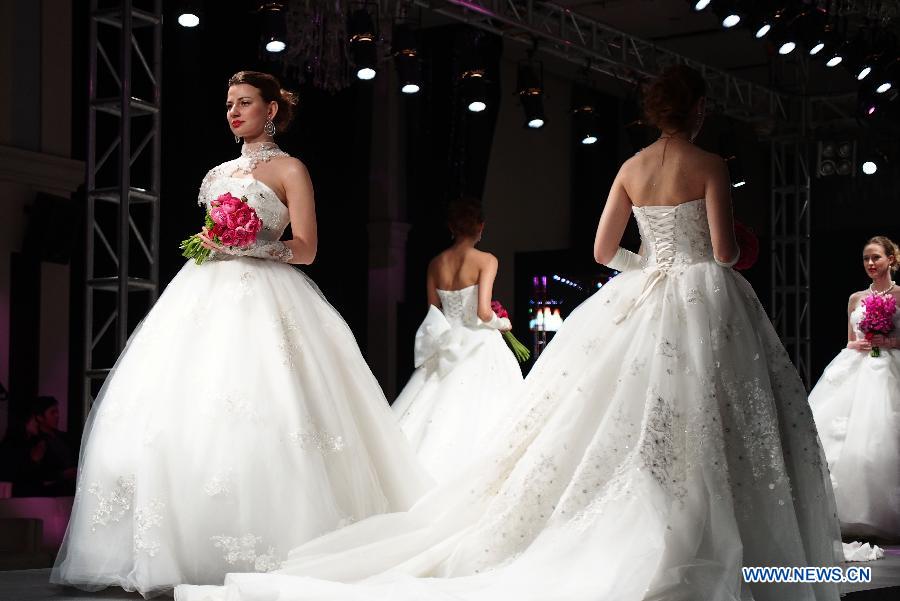  Models present creations at an international wedding dress show featuring 70 new designs in Shanghai, east China, Feb. 23, 2013. (Xinhua/Ren Long) 