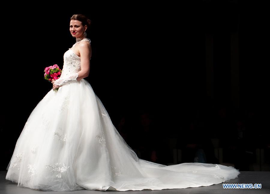 A model presents a creation at an international wedding dress show featuring 70 new designs in Shanghai, east China, Feb. 23, 2013. (Xinhua/Ren Long) 