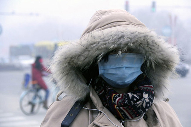 A citizen wearing breath mask goes outside in Liaocheng, Shandong on Feb 17, 2013. Heavy smog hit some regions in north China again.  
