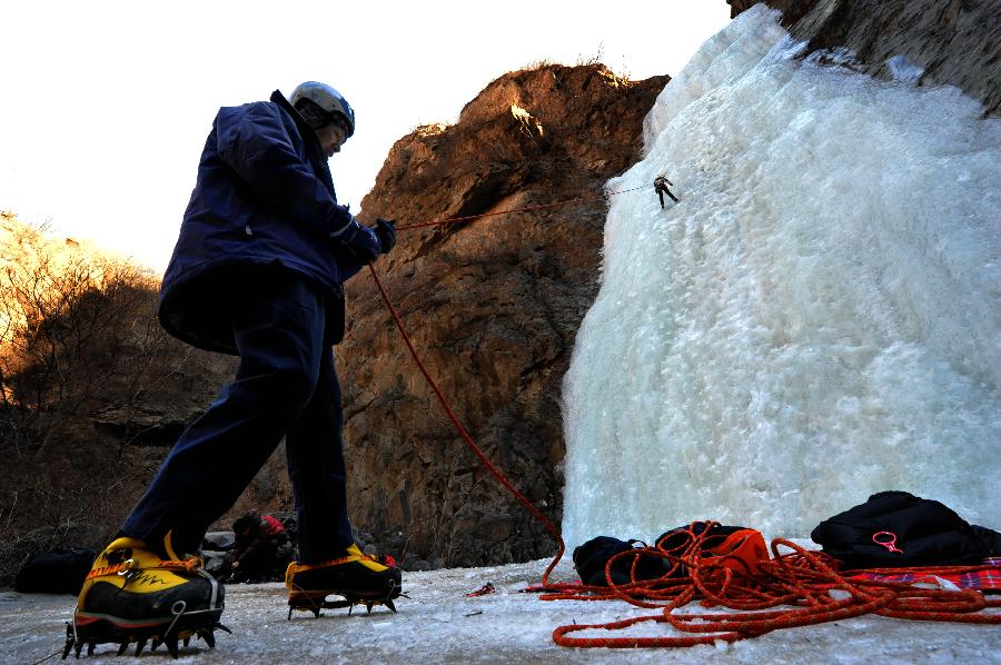 Tourists do ice climbing on a frozen waterfall in the Anjiazhuang Valley of Mentougou District, a suburb of Beijing, capital of China, Feb. 23, 2013. (Xinhua/Li Wenming) 