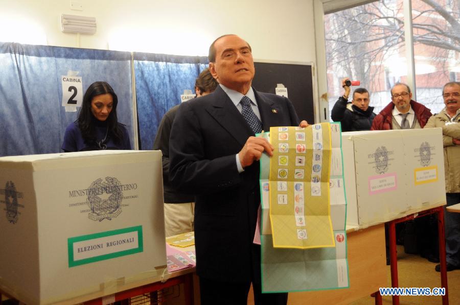 Italian ex-premier and media mogul Silvio Berlusconi holds ballots as he votes at the polling station in Milan, Italy, Feb. 24, 2013. Italians began voting for a new government Sunday, the outcome of which has had global markets and the country's European partners anxious about for weeks. (Xinhua/Angela Quattrone) 