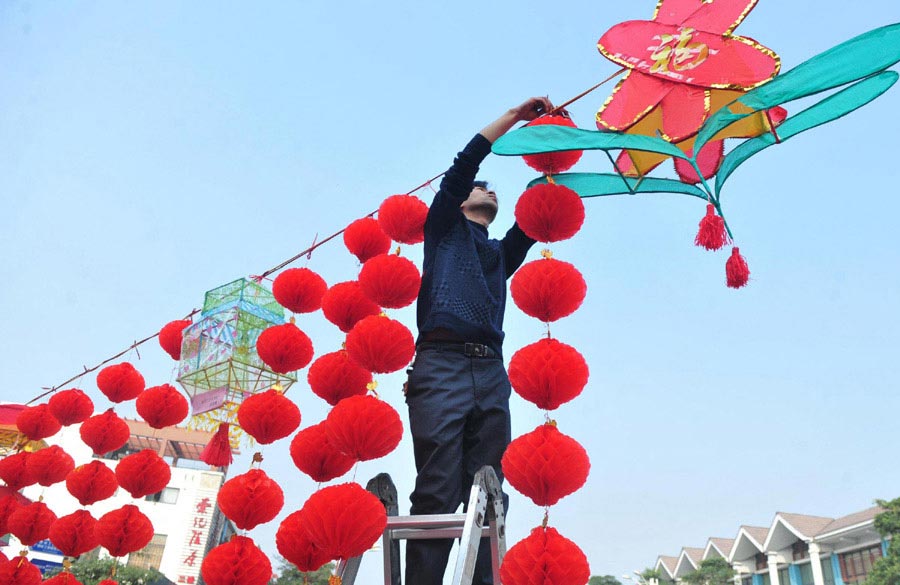 A resident hangs lanterns in Nanning, capital of Guangxi Zhuang autonomous region in Southwest China, on Feb 24. (Photo/Xinhua)