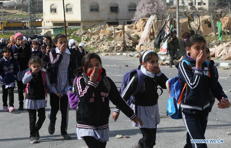 Palestinian schoolgirls cover their faces from tear gas fired by Israeli soldiers during clashes erupted in protest against the death of the Palestinian prisoner Arafat Jaradat in Asir town near the West Bank city of Hebron on Feb. 24, 2013. Thousands of Palestinian prisoners in Israeli jails rejected meals on Sunday to protest against an inmate's death a day earlier, local media reported. (Xinhua/Mamoun Wazwaz) 