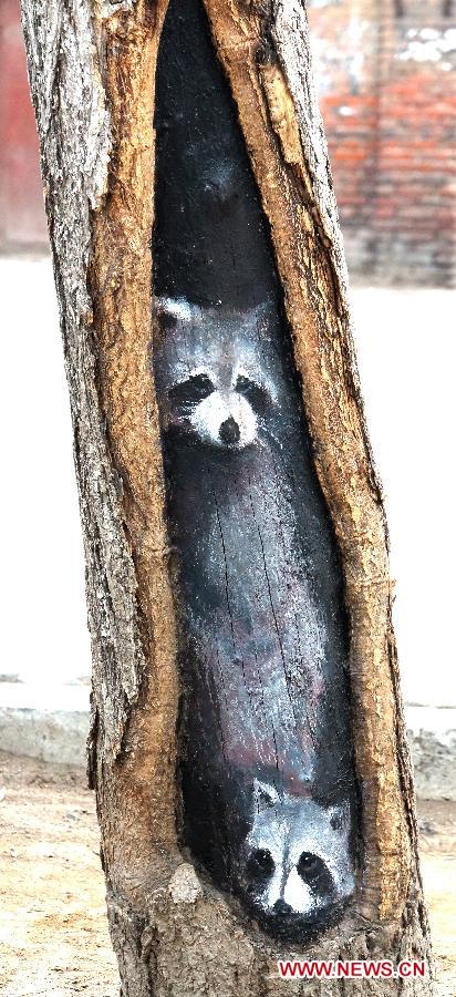 A tree hollow painting is seen at Jiuzhong street in Shijiazhuang, capital of north China's Hebei Province, Feb. 24, 2013. Paintings in shade tree hollows by Wang Yue, a local art student, became an Internet sensation lately. (Xinhua/Ding Lixin)