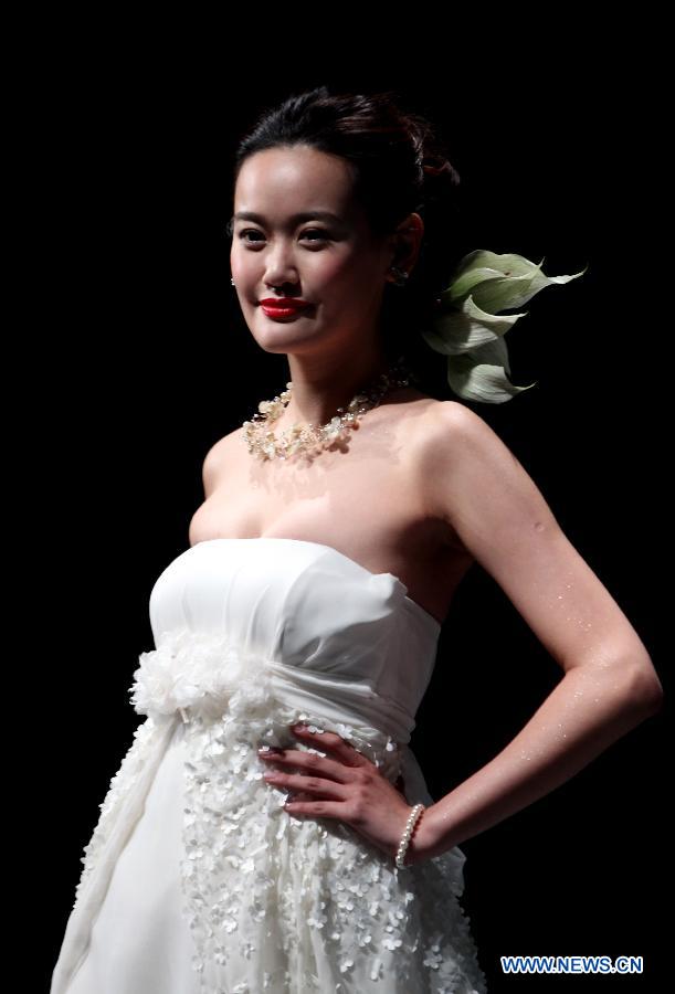 A model presents a creation at an international wedding dress show featuring 70 new designs in Shanghai, east China, Feb. 23, 2013. (Xinhua/Ren Long)