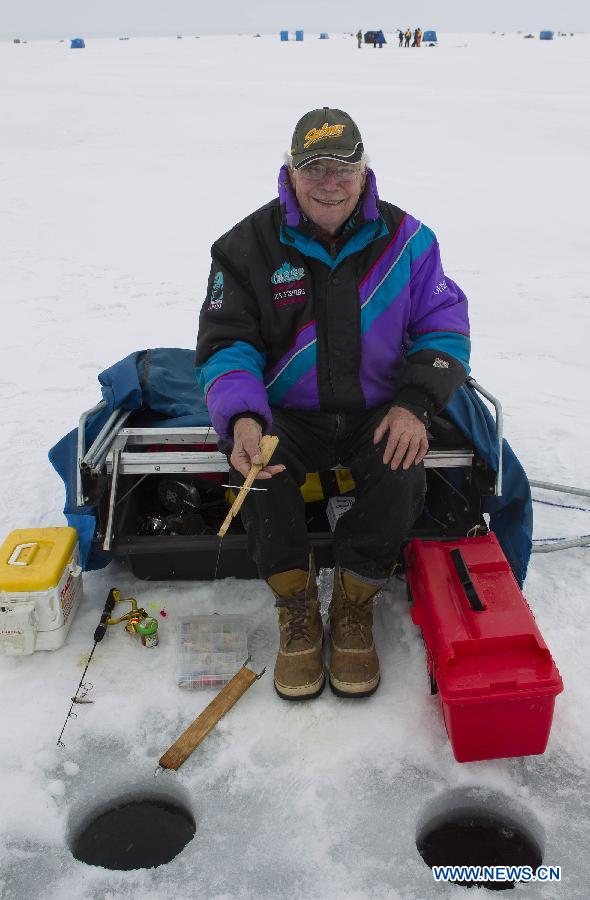 With 84 years' experience of fishing, 90-year-old Joe Montgomery sits on the ice to fish during the 19th Canadian Ice Fishing Championship on Lake Simco at Jackson's Point, Town of Georgina, Ontario, Canada, Feb. 24, 2013. The two-day competition kicked off on Saturday and attracted 96 anglers from the country and the United States. (Xinhua/Zou Zheng)