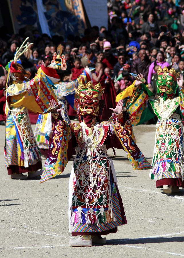 A masked Buddhist monk performs a ritual dance to pray for good fortune and harvest at the Labrang Monastery in Xiahe County, Gannan Tibetan Autonomous Prefecture, northwest China's Gansu Province, Feb. 23, 2013. The Labrang Monastery is among the six great monasteries of the Geluk school of Tibetan Buddhism. (Xinhua/Shi Youdong)