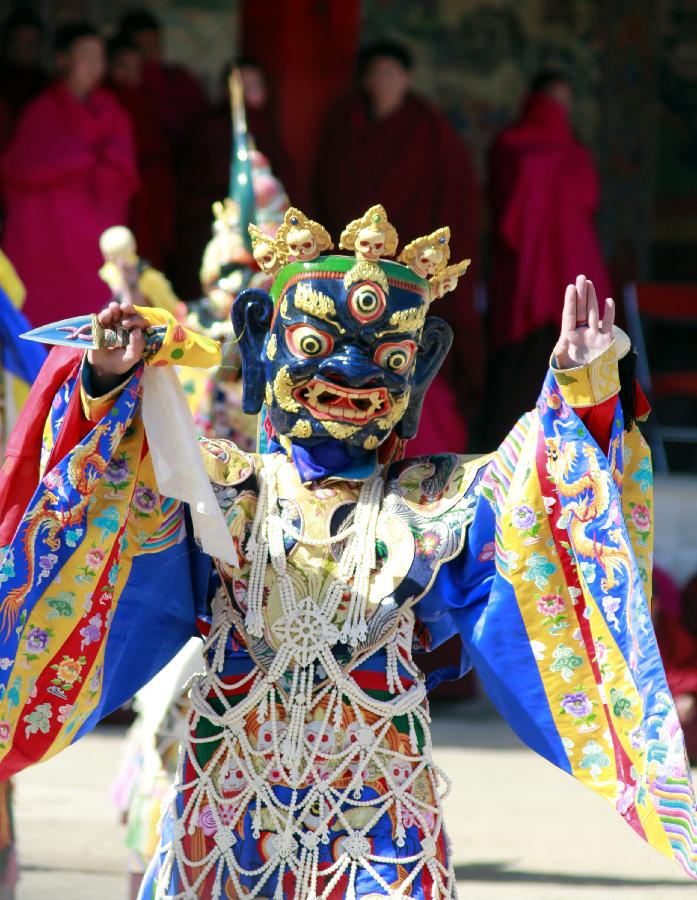 A masked Buddhist monk performs a ritual dance to pray for good fortune and harvest at the Labrang Monastery in Xiahe County, Gannan Tibetan Autonomous Prefecture, northwest China's Gansu Province, Feb. 23, 2013. The Labrang Monastery is among the six great monasteries of the Geluk school of Tibetan Buddhism. (Xinhua/Shi Youdong)