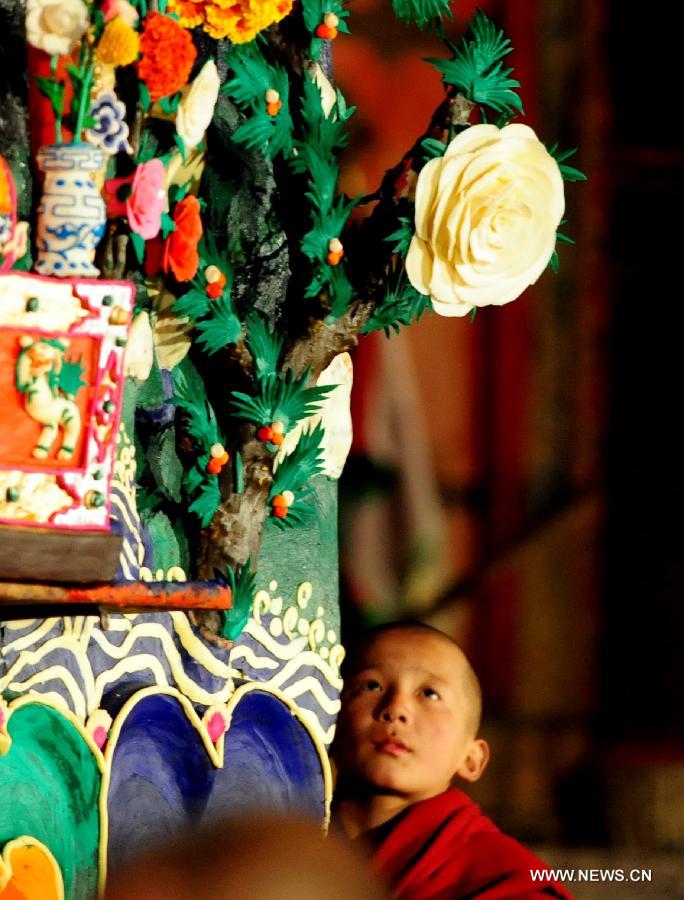 A young Buddhist monk views yak butter sculptures displayed at the Labrang Monastery in Xiahe County of Gannan Tibetan Autonomous Prefecture, northwest China's Gansu Province, Feb. 24, 2013. An annual yak butter sculpture show was held here on Sunday, the Chinese Lantern Festival, as a means to pray for good fortune and harvest. The Labrang Monastery is among the six great monasteries of the Geluk school of Tibetan Buddhism. (Xinhua/Zhang Meng) 