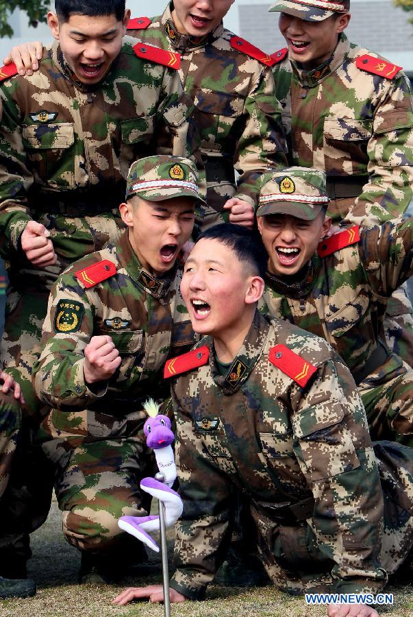 A member of Chinese People's Armed Police Force does push-ups while his fellows cheer up for him at a training session in Shanghai, east China, Feb. 25, 2013. (Xinhua/Chen Fei) 