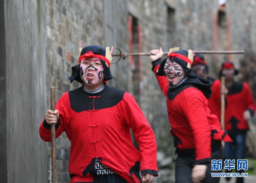 Children hold knives and folks to "chase the wild cats" in Huangling village of Pengze county in Jiangxi on Feb. 16, 2013. "Chasing wild cats" is an old ceremony of "exorcising devils", which has been passed down for hundreds of years in Pengze. Health and sportive boys disguised as ancient soldiers ran around the village to chase the devils and diseases with knives and folks. (Xinhua/Shen Junfeng)  