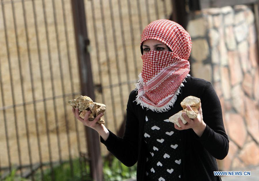 A female Palestinian protester throws stones at Israeli soldiers during clashes in the West Bank city of Bethlehem on Feb. 25, 2013. (Xinhua/Luay Sababa) 