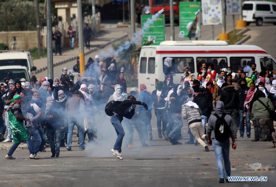 A Palestinian protester throws back a tear gas grenade at Israeli soldiers during clashes outside Ofer prison near the West Bank city of Ramallah on Feb. 25, 2013. (Xinhua/Fadi Arouri) 