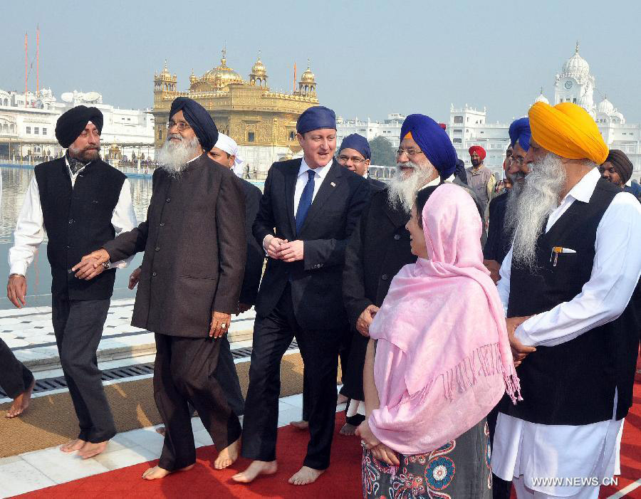 British Prime Minister David Cameron (C) visits the Golden Temple in Amritsar, India, Feb. 20, 2013. British Prime Minister David Cameron Wednesday paid homage to the victims of the 1919 killing of civilians by British troops in northwest Indian city of Amritsar. (Xinhua/Stringer) 