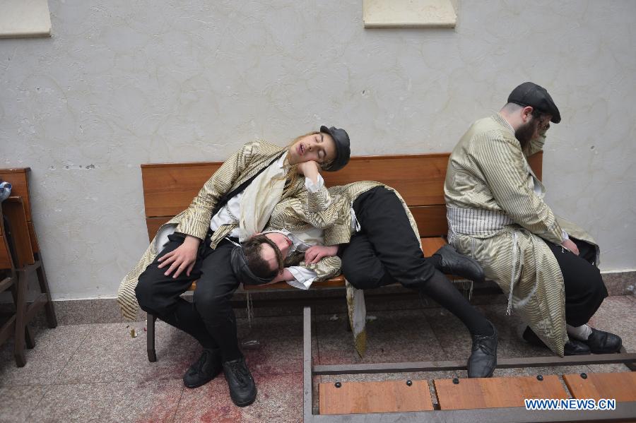 Ultra-Othordox Jews take a nap in a synagogue during Purim festival, a Jewish colorful and popular holiday, in Jerusalem, on Feb. 25, 2013. In Jerusalem, Purim was celebrated from sunset on Sunday, Feb. 24, until sunset on Monday, Feb. 25, one day later than it is in the rest of the world. (Xinhua/Yin Dongxun) 