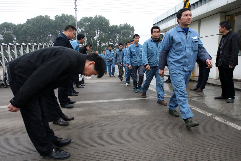 Managers at a company welcome employees returning to work after the Spring Festival holiday, in Taizhou, East China's Zhejiang province, Feb 25, 2013. The tradition began at the company in 2005, after long holidays. (Photo/News.china.com.cn) 