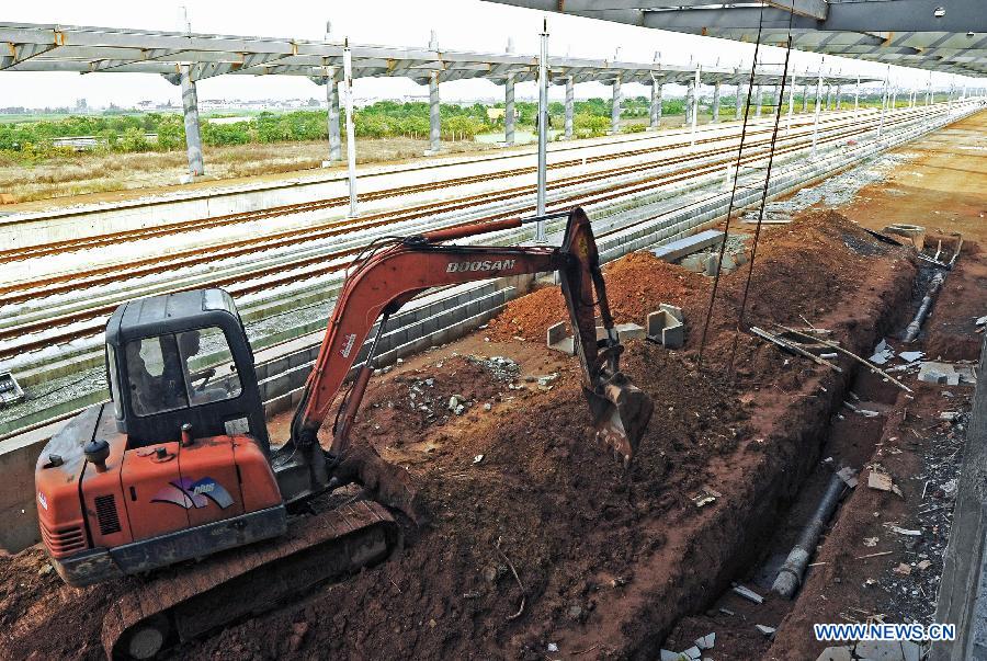 Photo taken on Oct. 21, 2011 shows an excavator working in the completing Shangyu railway station of the Hangzhou-Ningbo high-speed railway in Shangyu, east China's Zhejiang Province. Designed at a top speed of 350km/h, the 150-kilometer Hangzhou-Ningbo high-speed railway linking Hangzhou and Ningbo, two hub cities in Zhejiang, will reduce the travel time to 36 minitues when it is put into operation in July 2013, as expected. (Xinhua/Tan Jin) 