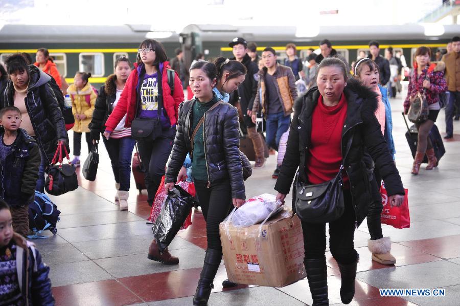 Passengers walk out of the railway station in Lhasa, capital of southwest China's Tibet Autonomous Region, Feb. 26, 2013. Lhasa rail station saw a daily of some 3,700 arrivals as migrant workers returned Lhasa to work after the annual Spring Festival holidays. (Xinhua/Liu Kun) 
