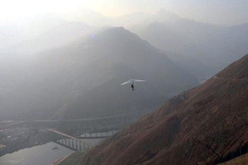 Yi Ruilong, 70, rides a delta wing hang glider across the Taihuang Mountains in Hanyuan County of southwest China's Sichuan Province, on Sunday February 24, 2013 shortly before his death after dropping into a remote lake. After two days of searching, his body was found on Tuesday night in the lake. (Photo: Xinhua)