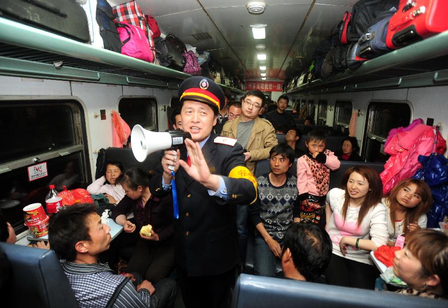 A train staff member tells passengers about safety items with a speaker on a train to send migrant workers to Urumqi, capital of northwest China's Xinjiang Uygur Autonomous Region, at Longxi Railway Station in Longxi County, northwest China's Gansu Province, Feb. 26, 2013. Many migrant workers started their journey to work away home after the Chinese Spring Festival holidays. (Xinhua/Nie Jianjiang) 