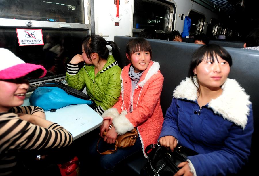 Girls take a train to Urumqi, capital of northwest China's Xinjiang Uygur Autonomous Region, for work at Longxi Railway Station in Longxi County, northwest China's Gansu Province, Feb. 26, 2013. Many migrant workers started their journey to work away home after the Chinese Spring Festival holidays. (Xinhua/Nie Jianjiang)
