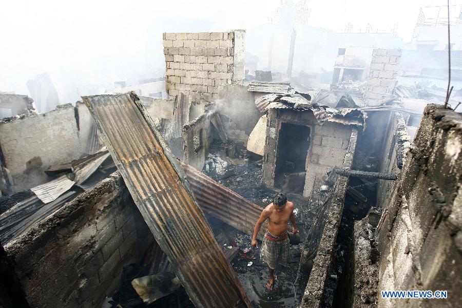 A resident check his burnt home after a fire hit a residential area in Valenzuela City, the Philippines, Feb. 27, 2013. More than 400 shanty houses were destroyed by the fire, leaving 500 families homeless. (Xinhua/Rouelle Umali) 