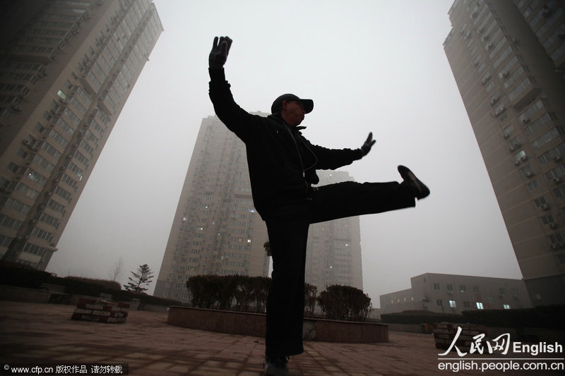 A Beijing citizen practices tai chi in haze, Feb. 28, 2013. Sand and haze hit Beijing in a row from Wednesday, causing serious air pollution and poor visibility. The Meteorological Bureau of Beijing issued blue alert for strong gale and yellow alert for haze yesterday. (Photo/CFP)