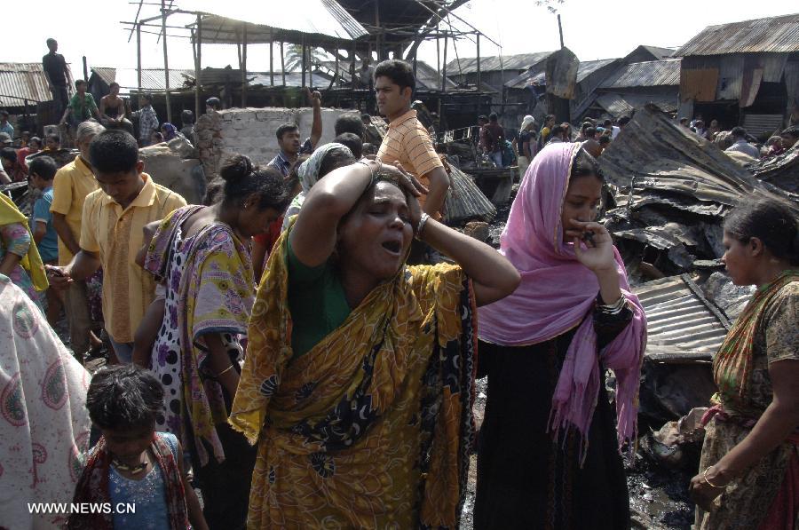  Women react after a fire broke out at a slum at Kalyanpur area in Dhaka, capital of Bangladesh, Feb. 27, 2013. About 150 shanties were destroyed, fire brigade said. (Xinhua/Shariful Islam) 