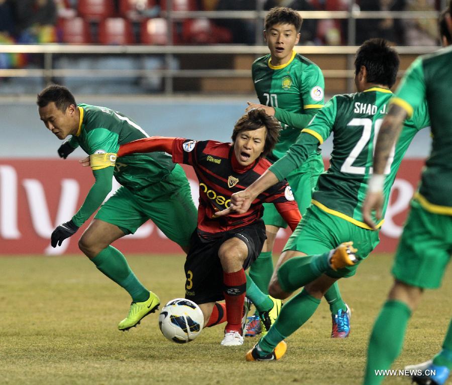 Kim Kwang-suk (C) of South Korea's Pohang Steelers fight for the ball during their AFC Champions League 2013 group G match against China's Beijing Guoan at the Pohang Steelyard Stadium, in Pohang, Gyeongsangbukdo province of South Korea, Feb. 27, 2013. The match ended in a 0-0 draw. (Xinhua/Park Jin Hee)