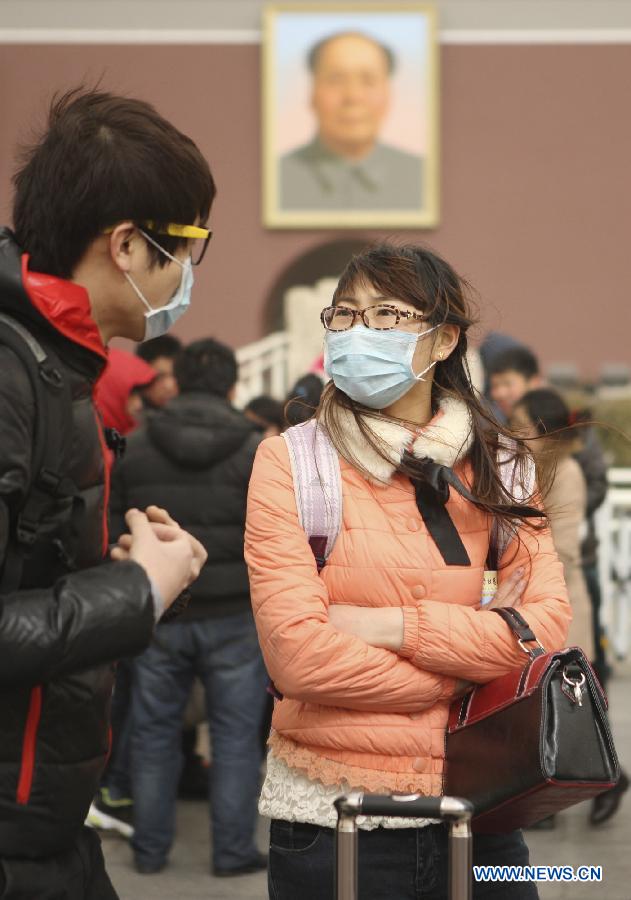 Two masked tourists are seen at the Tian'anmen in Beijing, capital of China, Feb. 28, 2013. Beijing was hit by heavy fog on Thursday morning. The fog led to reduced visibility and degenerated air quality. The city also issued high wind and haze alerts on the same day. (Xinhua/Liu Changlong)