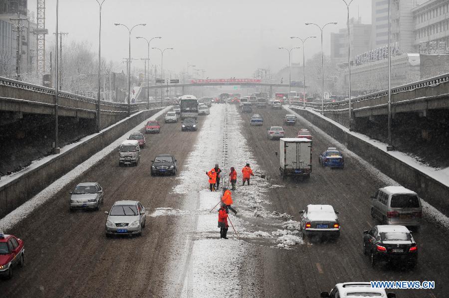 Sanitation workers remove snow on a road in Shenyang, capital of northeast China's Liaoning Province, Feb. 28, 2013. Liaoning was hit by a snowstorm on Thursday. (Xinhua/Pan Yulong)