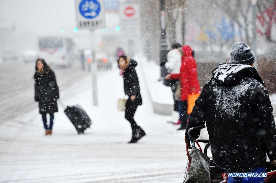 People wait for taxi in the snow in Harbin, capital of northeast China's Heilongjiang Province, Feb. 28, 2013. Most areas of Heilongjiang witnessed snowfall on Thursday. (Xinhua/Wang Jianwei) 