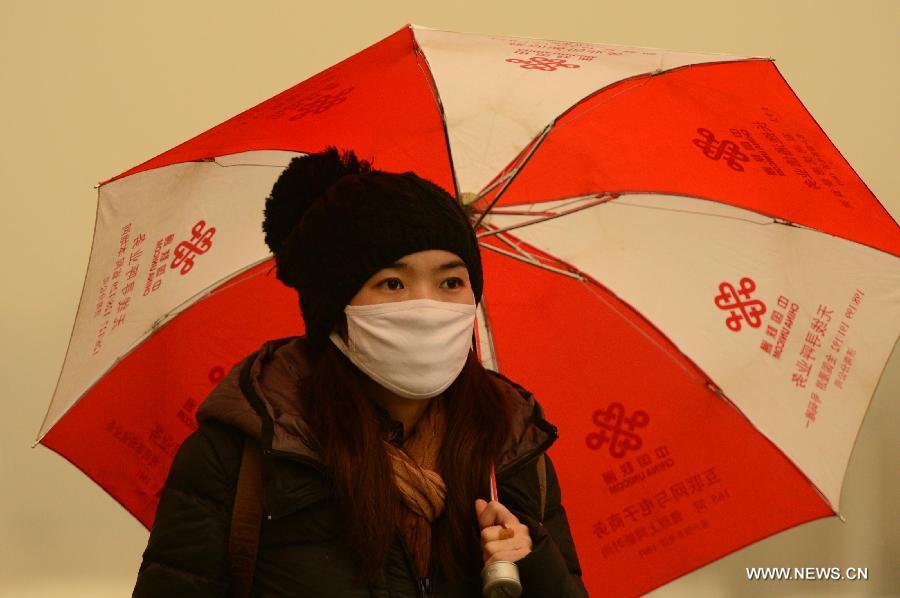 A women wearing a facemask walks in a hazy day in Jinan, capital of east China's Shandong Province, Feb. 28, 2013. Pollution worsened in China's north and east provinces as a sand storm hit the region on Thursday. (Xinhua/Guo Xulei) 