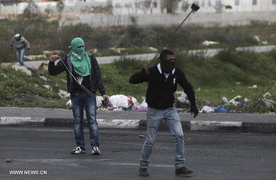 Palestinian protesters hurl stones at Israeli soldiers outside Ofer Prison near Ramallah on Feb. 28, 2013, following a protest supporting Palestinian prisoners. Israeli troops arrested 3 protesters and 19 were reportedly injured. (Xinhua/Fadi Arouri)