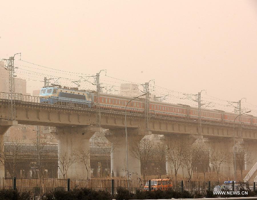 A train runs amid dust and sand in Beijing, capital of China, Feb. 28, 2013. A cold front blew away fog and smog which hit Beijing on Feb. 28 morning, but brought dust and sand from Mongolia and north China's Inner Mongolia Autonomous Region. (Xinhua/He Junchang)