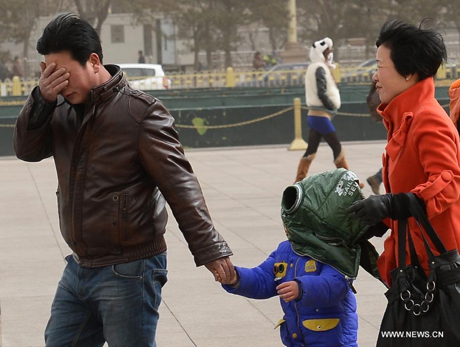 Tourists brave wind as they visit the Tian'anmen Square in Beijing, capital of China, Feb. 28, 2013. A cold front blew away fog and smog which hit Beijing on Feb. 28 morning, but brought dust and sand from Mongolia and north China's Inner Mongolia Autonomous Region. (Xinhua/Jin Liangkuai)