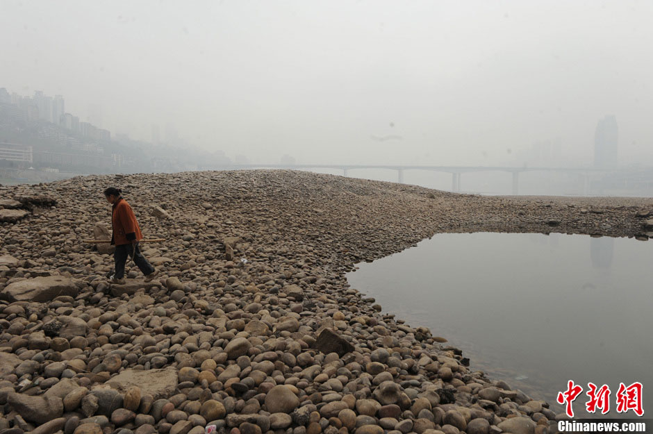 A local is walking across a dry riverbed. (Photo/Chinanews.com)