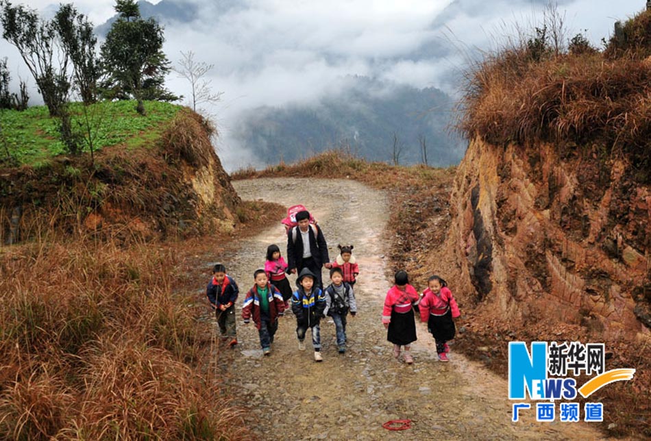 Yu Qigui carries basket on his back and lead students to school on Feb. 26, 2013. (Photo/Xinhua)