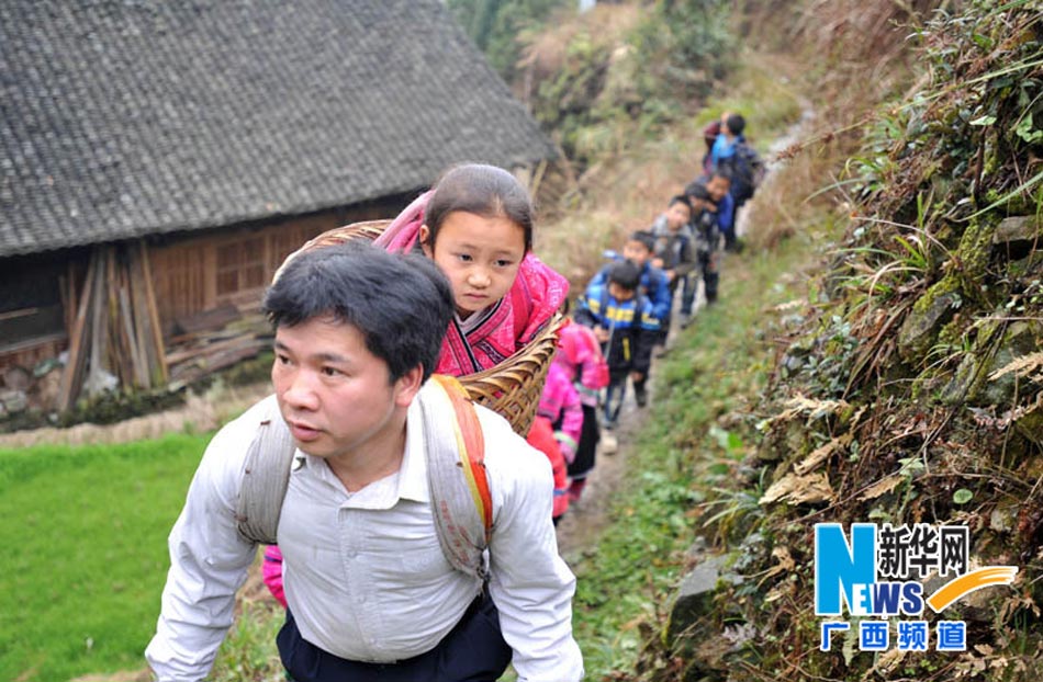 Yu Qigui carries a student in his back basket and leads others to school on Feb. 26, 2013. (Photo/Xinhua)