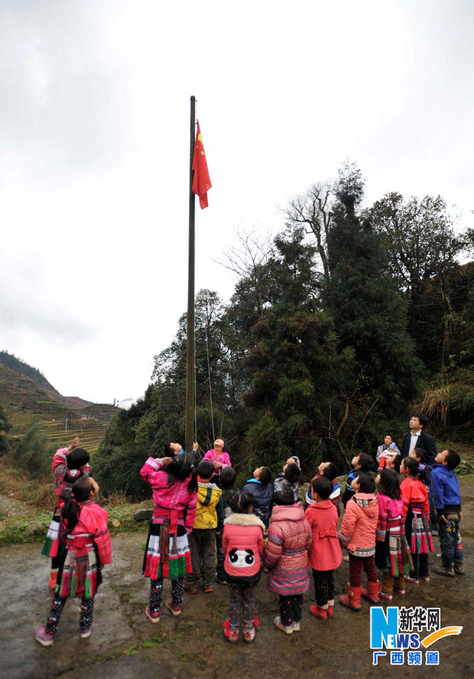 Yu Qigui and his students raise national flag on Feb. 26, 2013. (Photo/Xinhua) 
