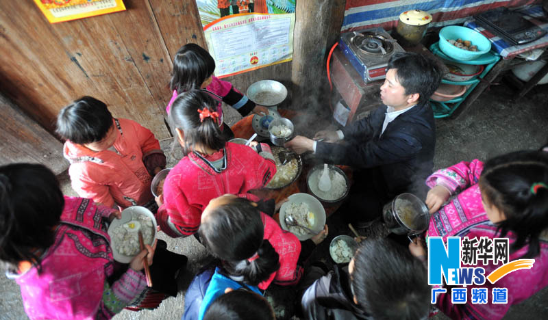 Yu Qigui distributes lunches to students on Feb. 26, 2013. (Photo/Xinhua) 