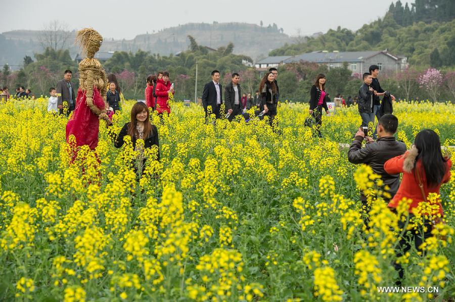 Tourists walk in the rape flower field during the 6th rape flower festival in Tongnan County, southwest China's Chongqing Municipality, March 1, 2013. The festival will last until late March. (Xinhua/Chen Cheng) 