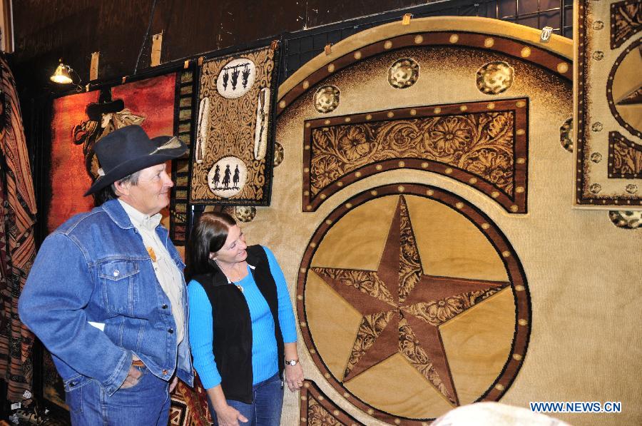 Visitors look at a tapestry made of leather in Houston, the United States, Feb. 28, 2013. Houston Live Stock Show and Rodeo is held during Feb. 25 to March 17 in Reliant Park in Houston, which is a city of rodeo culture. The rodeo was held yearly since 1932, and has become the biggest rodeo in the world. (Xinhua/Zhang Yongxing) 