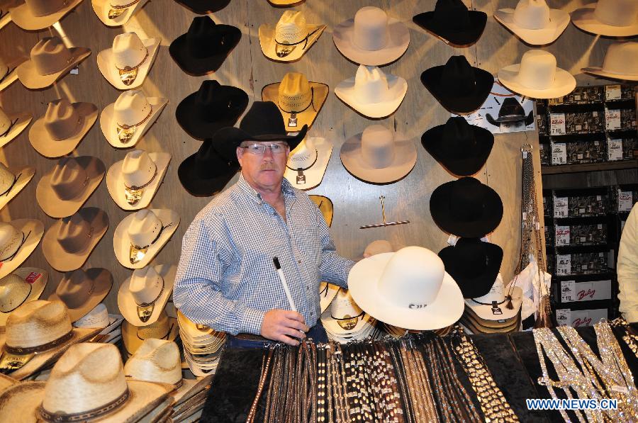 A man shows some cowboy hat in Houston, the United States, Feb. 28, 2013. Houston Live Stock Show and Rodeo is held during Feb. 25 to March 17 in Reliant Park in Houston, which is a city of rodeo culture. The rodeo was held yearly since 1932, and has become the biggest rodeo in the world. (Xinhua/Zhang Yongxing)