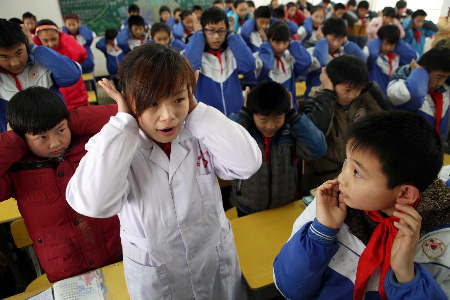 Students do ear exercises during an activity celebrating the upcoming Ear-care Day, which falls on March 3 every year, at a primary school in Maanshan City, east China's Anhui Province, March 1, 2013. (Xinhua/Cheng Qianjun)