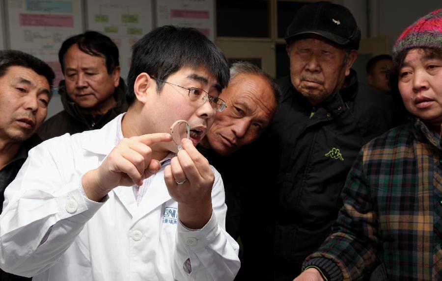 A staff member introduces the knowledge of hearing-aid to the elders during an activity celebrating the upcoming Ear-care Day, which falls on March 3 every year, in Beijing, capital of China, March 1, 2013. (Xinhua/Bu Xiangdong)