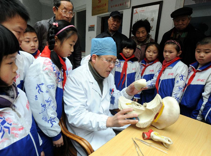 A volunteer from a local hospital introduces the general knowledge of protecting ears to the students and masses during an activity celebrating the upcoming Ear-care Day, which falls on March 3 every year, in Suzhou, east China's Jiangsu Province, March 1, 2013. (Xinhua/Hang Xingwei)